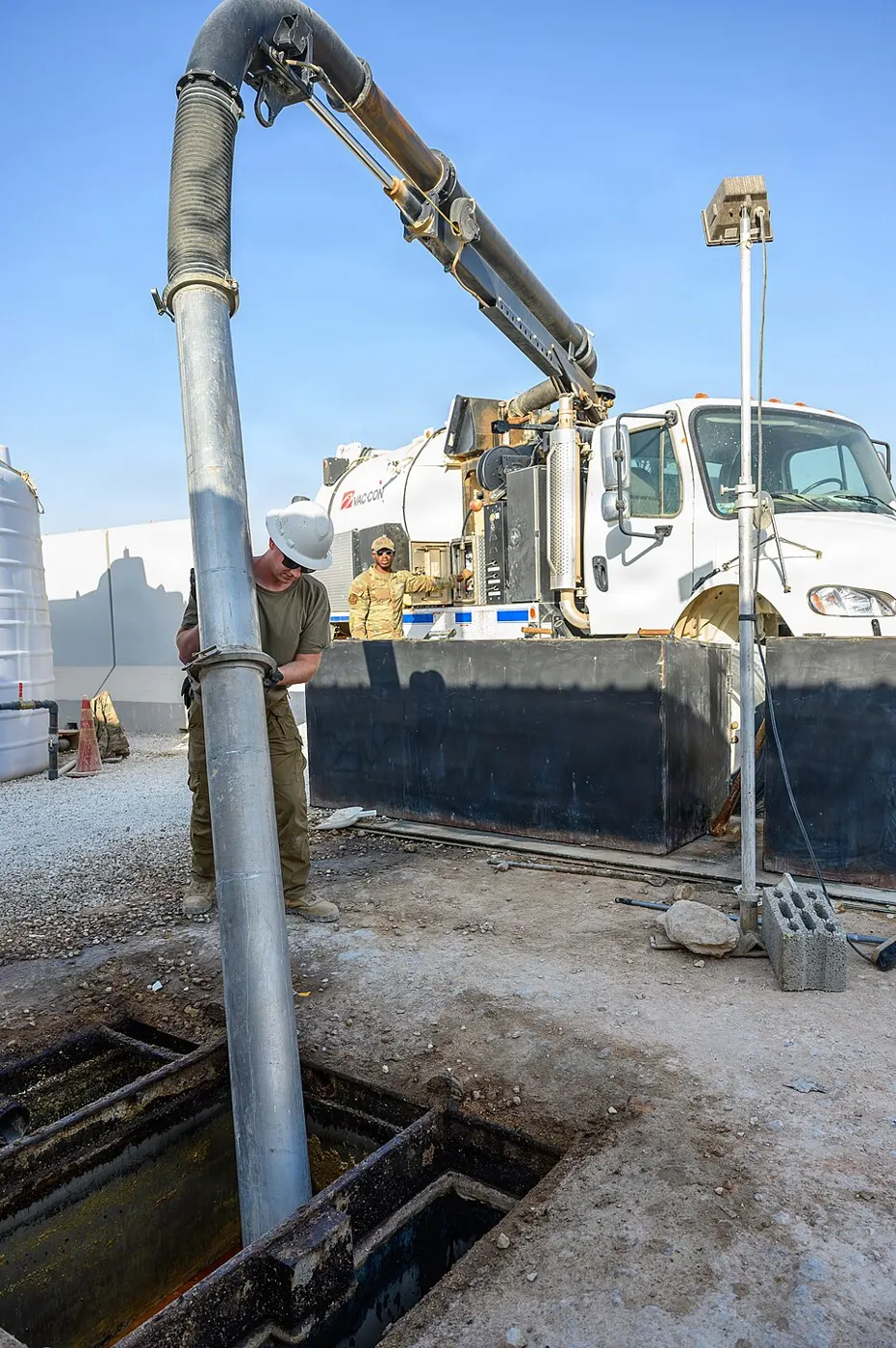 Vacuum truck hose running into an in-ground grease interceptor