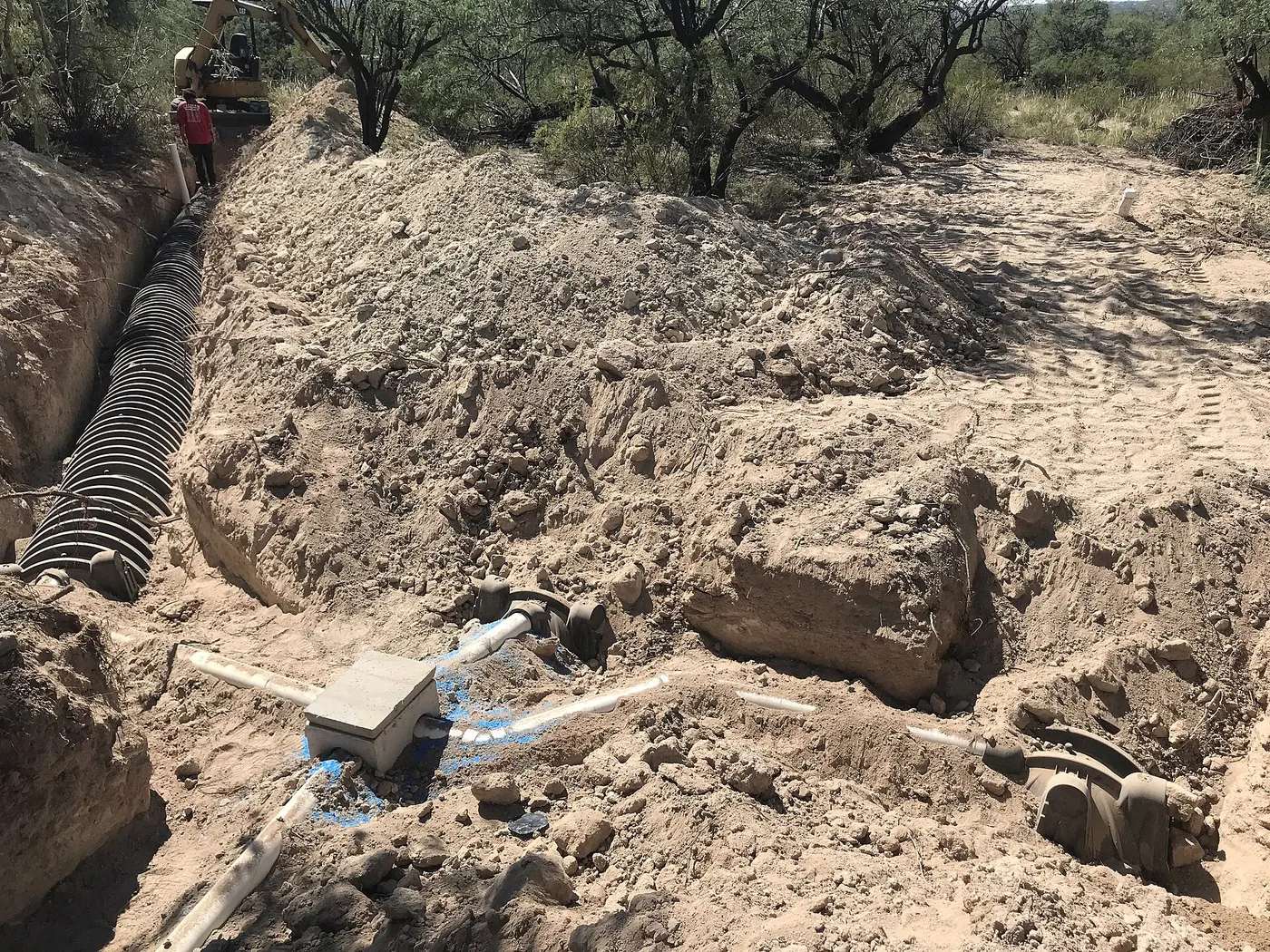 Leach field trench with chamber pipe being installed