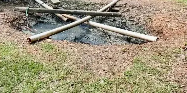 Wastewater pooled in a yard around exposed sections of pipe